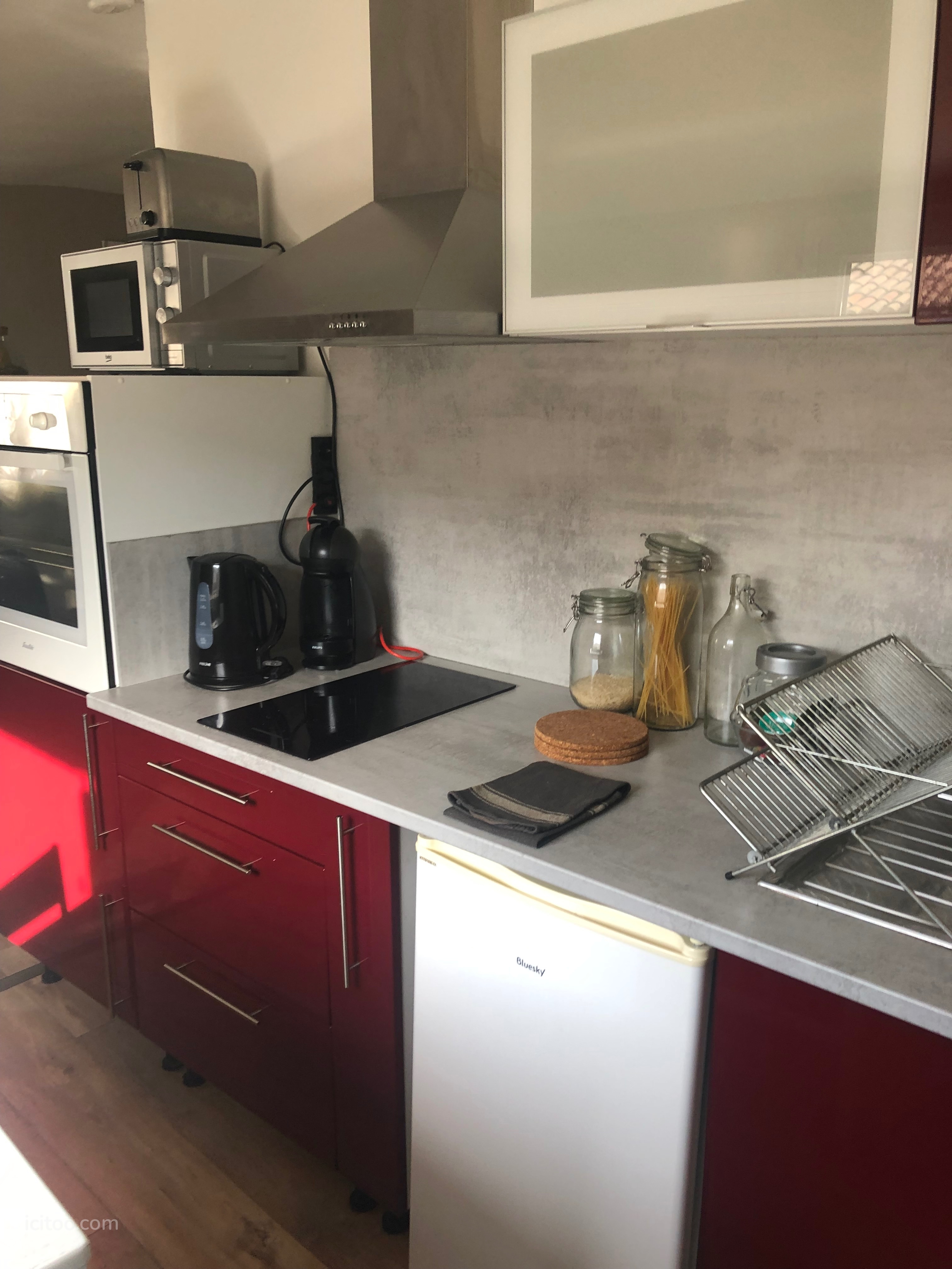 Détail de la cuisine équipée avec plaques induction et électroménager dans un appartement à Nîmes