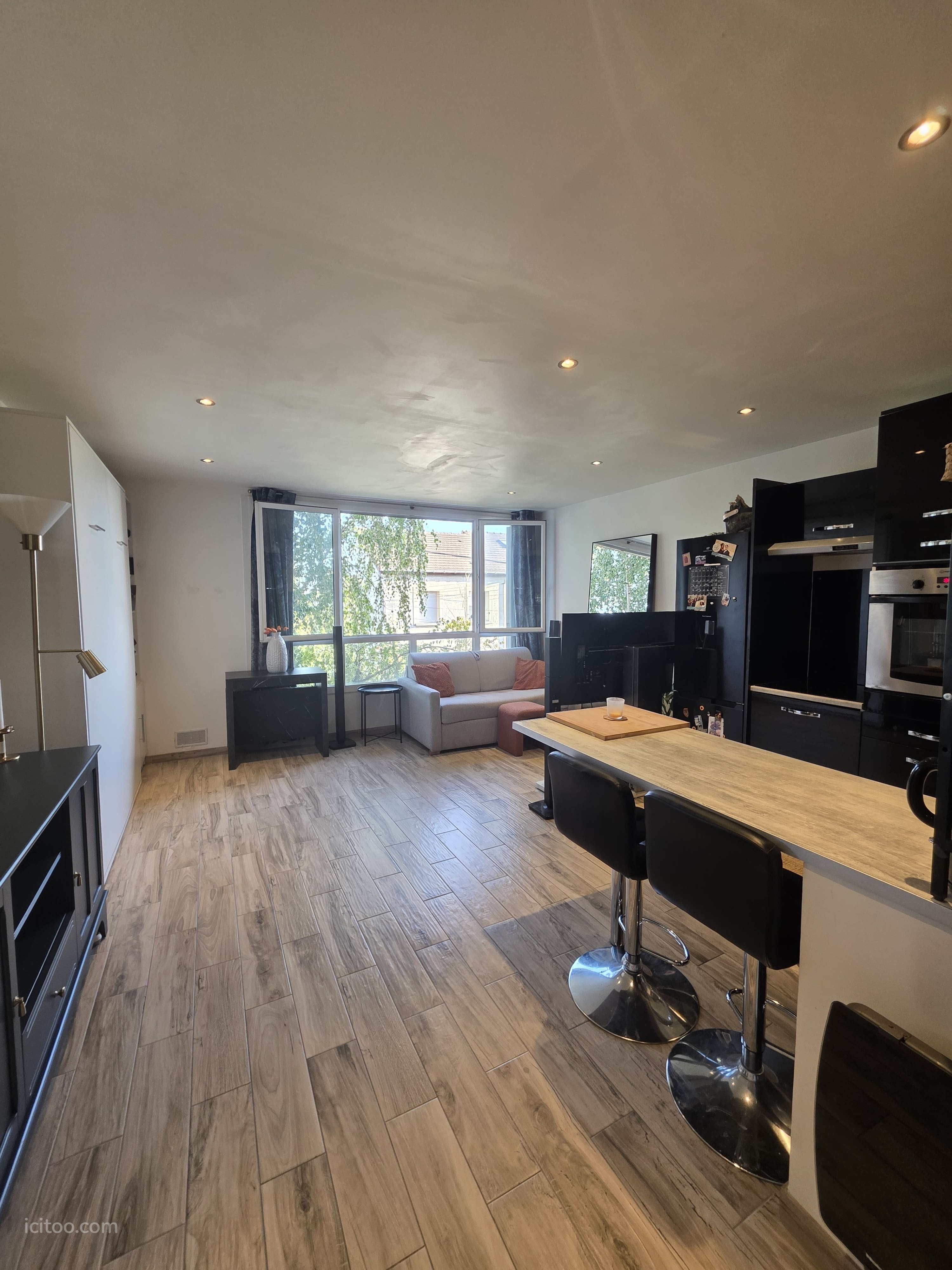 Studio/T1 à vendre à Houilles, salon et cuisine aménagée avec vue dégagée sur l'extérieur.