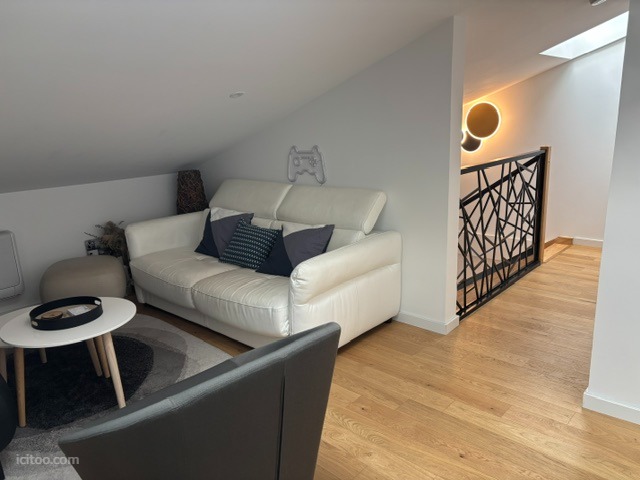 Salon cosy avec canapé blanc, table basse et escalier design, appartement à vendre à Toulouse.