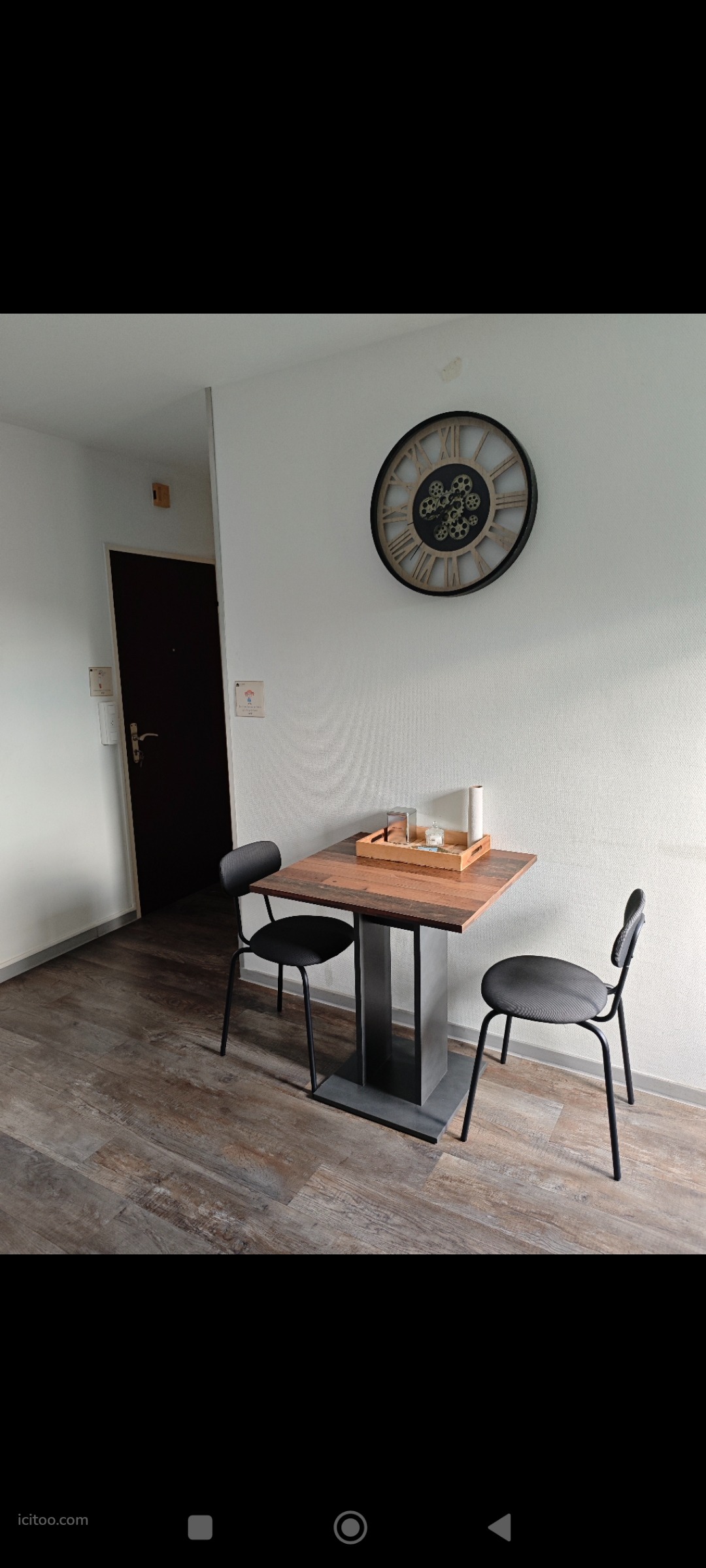 Coin repas dans studio à vendre à Saint-Louis avec table carrée et chaises industrielles.
