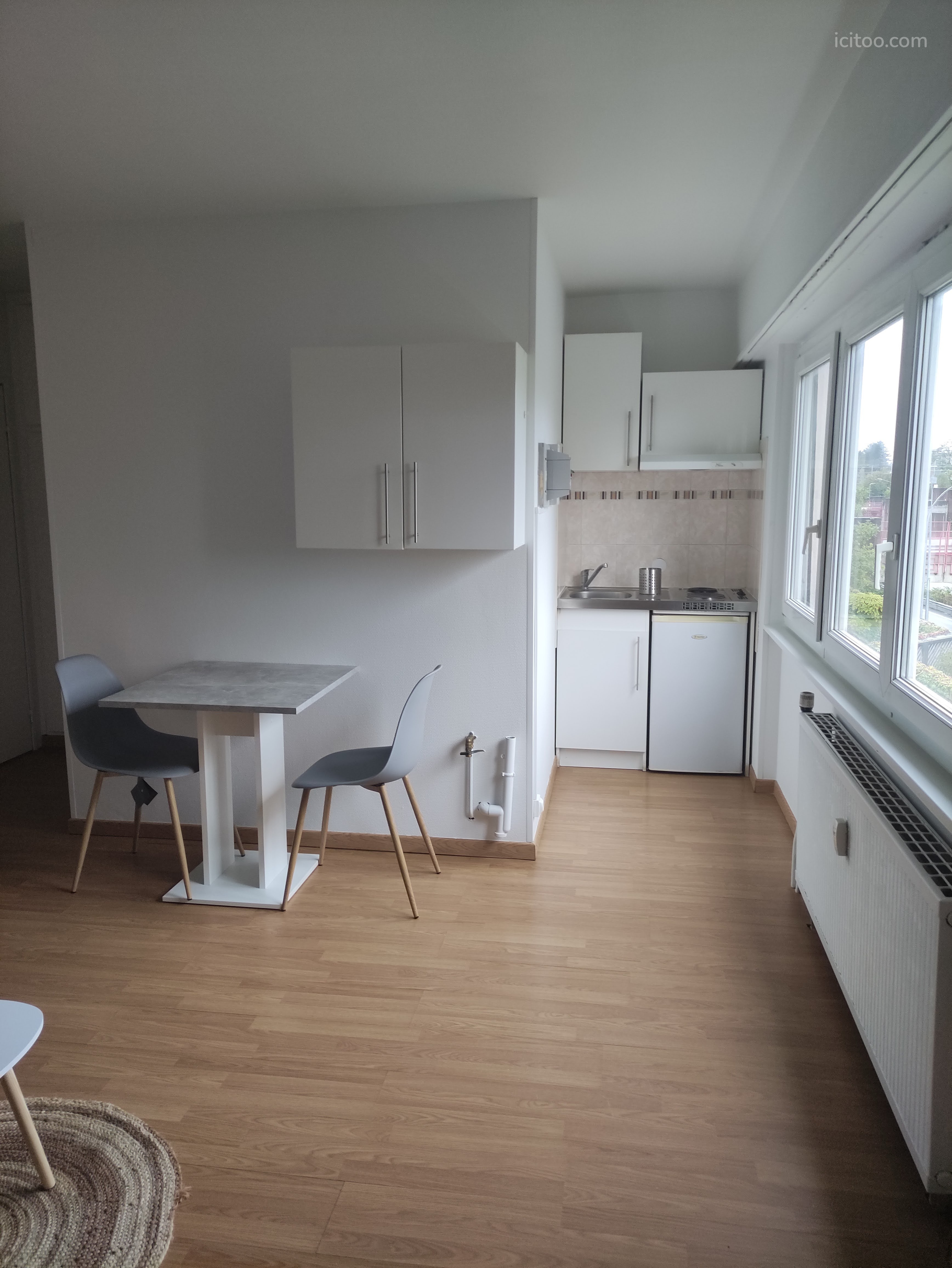 Pièce de vie lumineuse avec coin repas et cuisine aménagée dans studio à vendre à Saint-Louis.