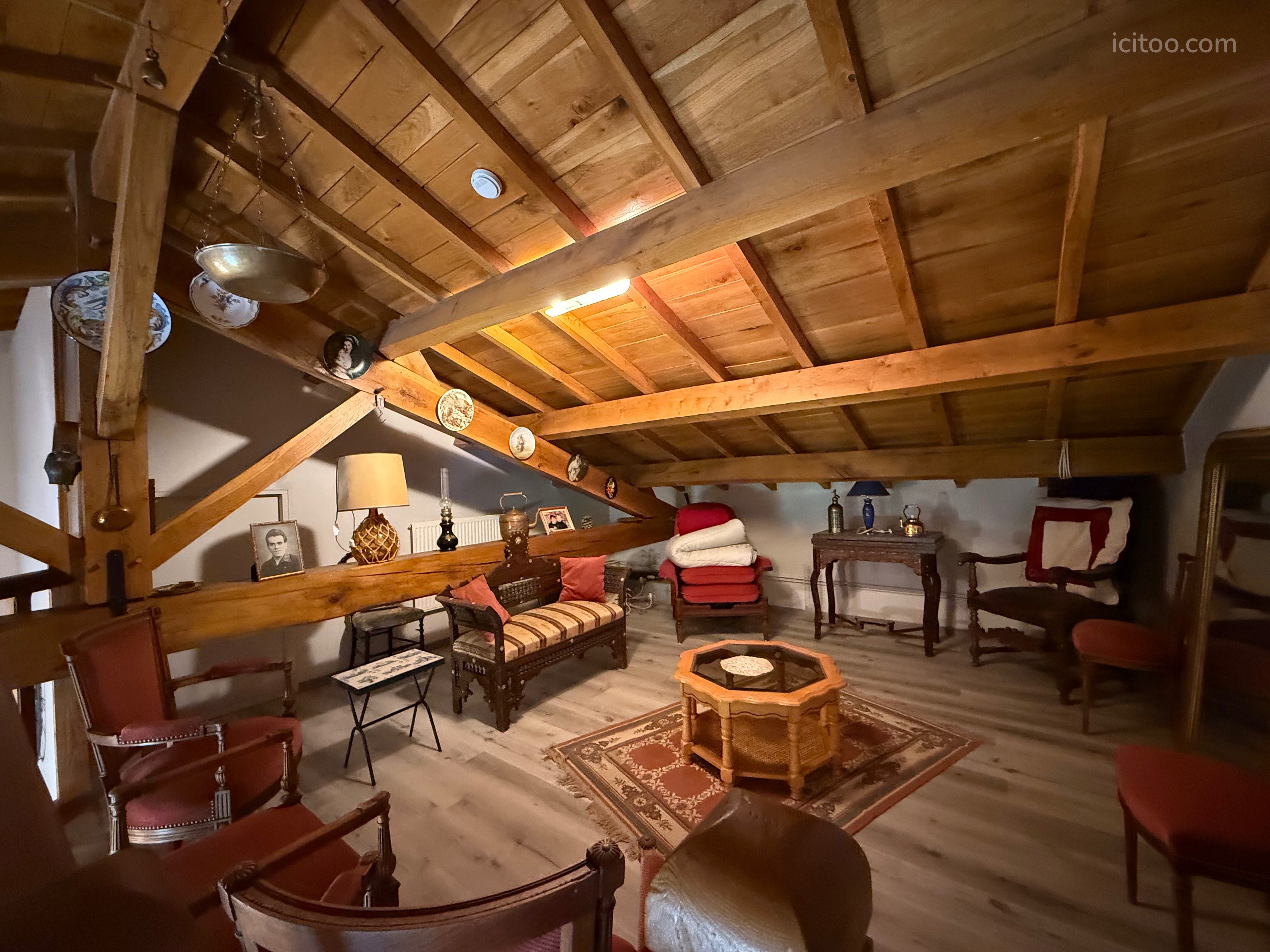 Grenier aménagé avec mobilier ancien, tapis et poutres apparentes, maison à vendre à Landorthe.