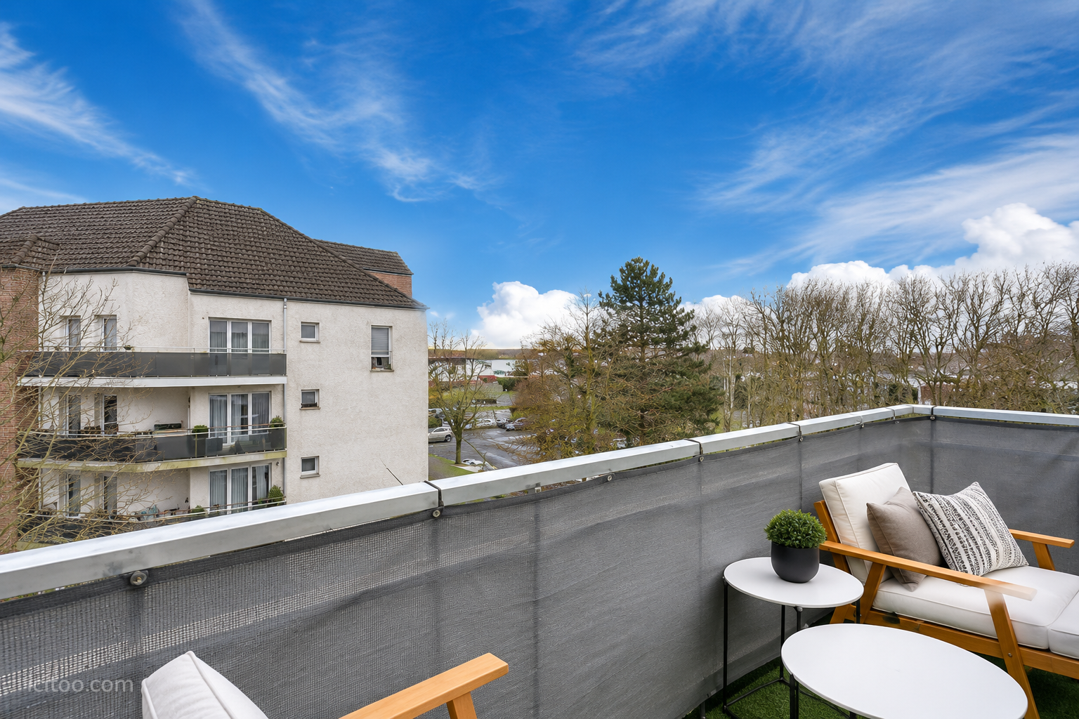 Balcon aménagé avec mobilier de jardin offrant une vue sur la résidence et les arbres à Pontault-Combault.