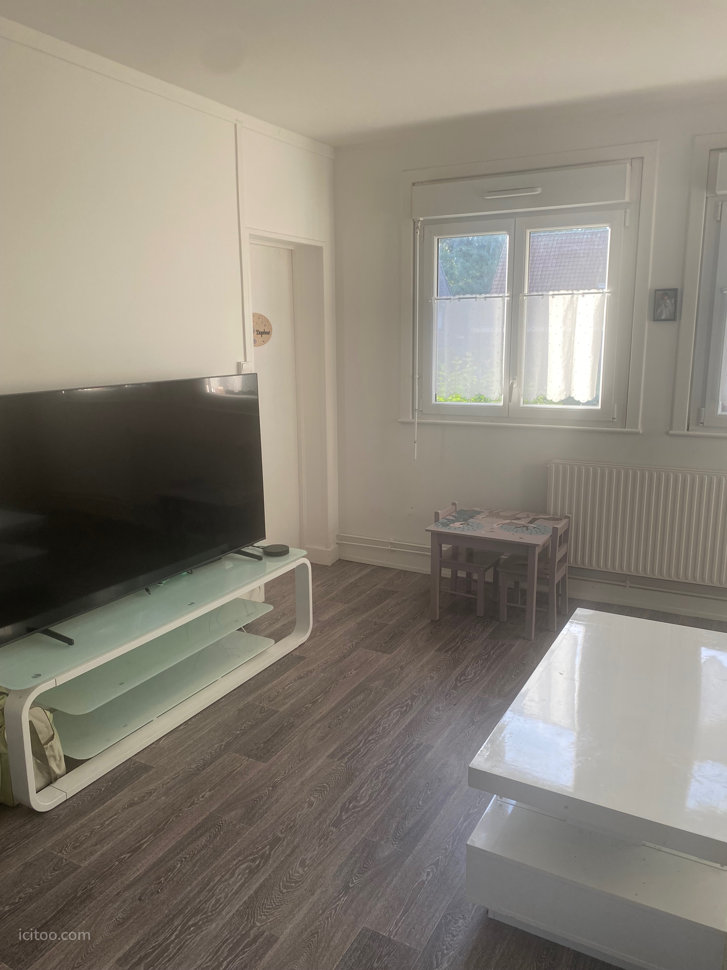Séjour avec télévision grand écran, table basse et fenêtre, appartement à vendre à Tourcoing.
