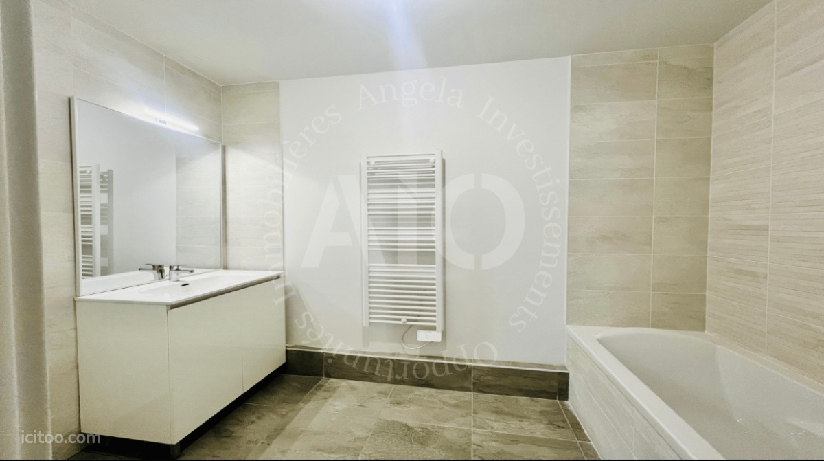 Salle de bain moderne avec baignoire et lavabo dans un appartement à Fontaines-sur-Saône.