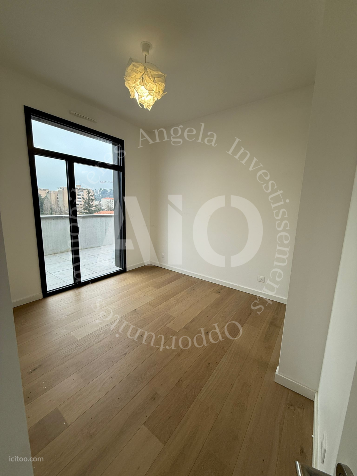 Chambre lumineuse avec parquet en bois clair et accès balcon à Tassin-la-Demi-Lune