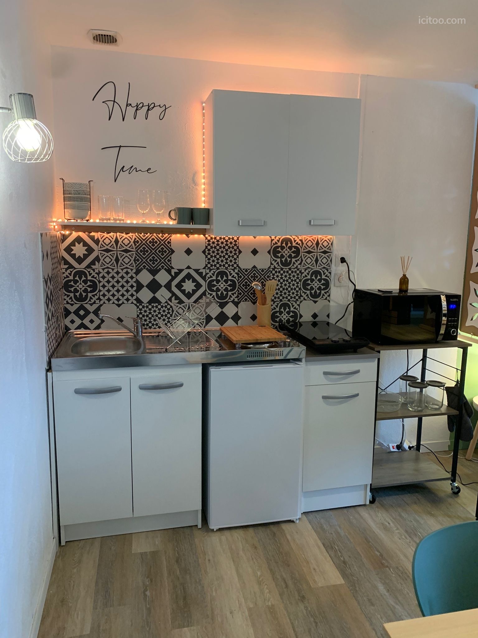 Cuisine équipée compacte avec évier, plaques de cuisson et micro-ondes, appartement à louer à Vierzon.